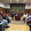 Estudiantes sentados en el salón de grados escuchando a Fernando Latorre