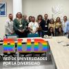 Foto de grupo de todos los participantes en el encuentro posando de pie sorientes con sus acreditaciones colgadas del cuello