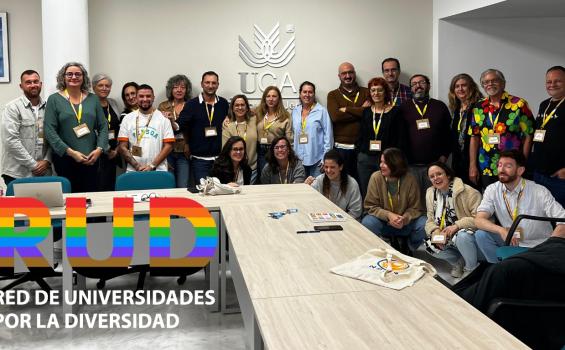 Foto de grupo de todos los participantes en el encuentro posando de pie sorientes con sus acreditaciones colgadas del cuello