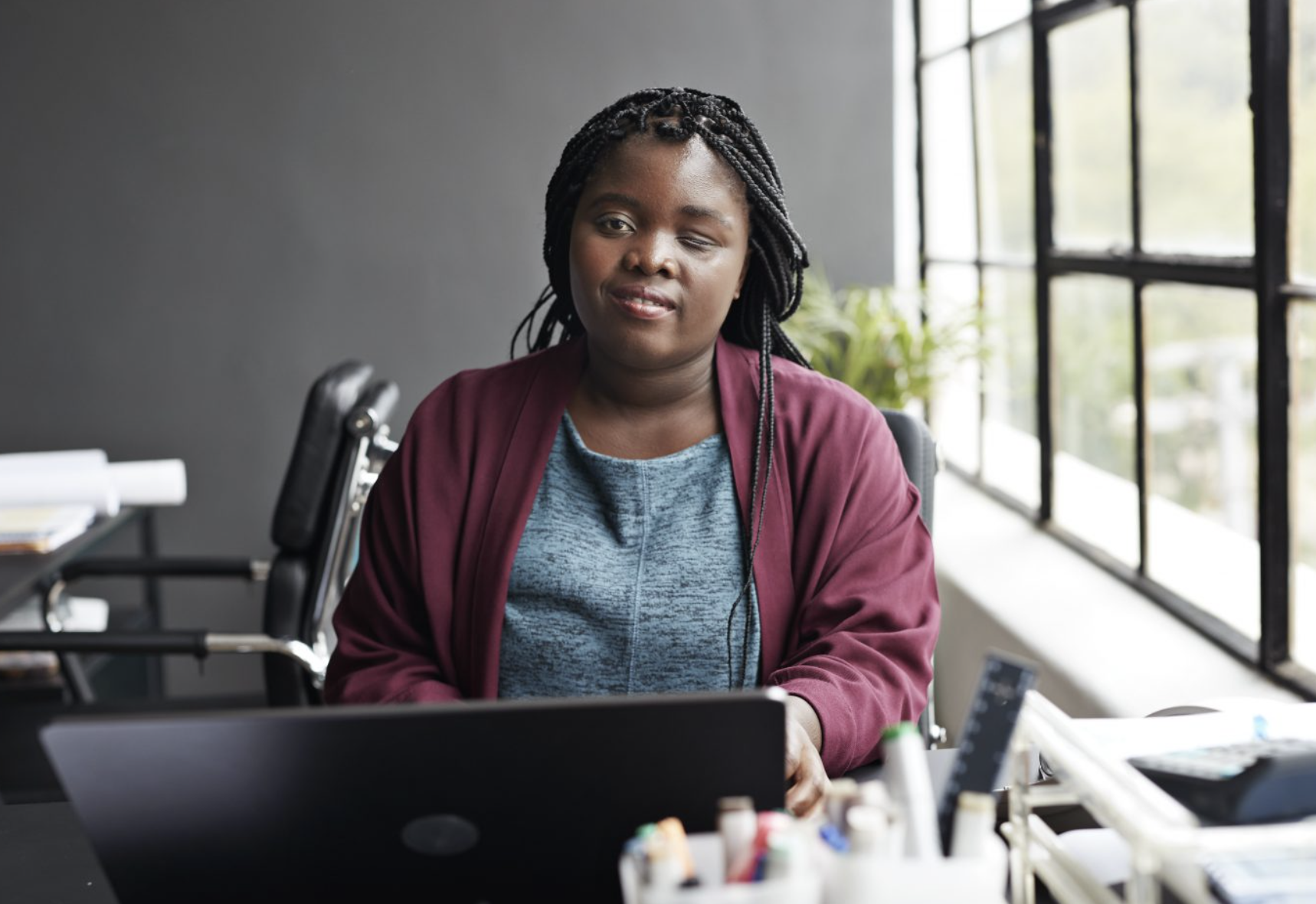 Mujer afroamericana con discapacidad visual usando un ordenador portátil